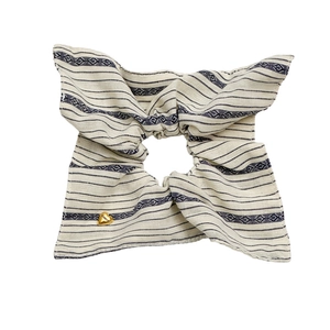 Striped fabric bow hair scrunchie with beige knit patterns and golden heart charm