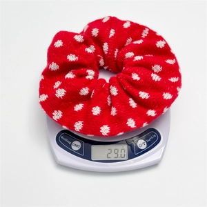 Detailed scale view showing the 29g weight of this red knitted polka dot hair scrunchie
