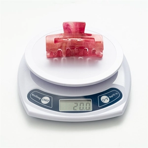 Detailed view of pink marble star hair claw clip showing precise 20.0g weight on scale