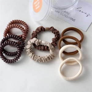 Detailed set of spiral telephone wire hair ties and fabric scrunchies in earth tones