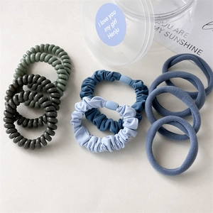Close-up of a 10-piece set of spiral phone cord and pleated fabric hair ties in soft tones