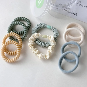 Detailed view of Morandi-colored telephone cord hair ties and pleated fabric elastics