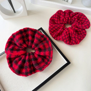 Detail of red and black buffalo check and argyle knitted scrunchies set in cozy fabric
