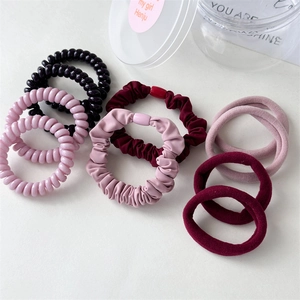 Close-up of assorted phone cord hair ties and scrunchies in pink and burgundy shades