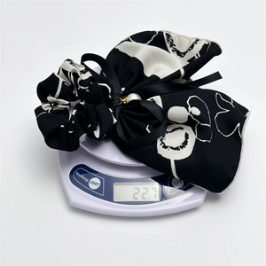 Ink style scrunchie with black ribbon bow and pearl bead, weighing 22.7g on scale