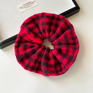 Close-up of red and black checkered knit oversized scrunchie with soft wool texture