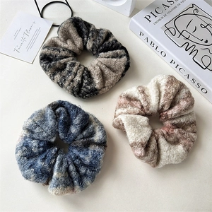Close-up of three plush wool scrunchies in autumn colors for winter hairstyling