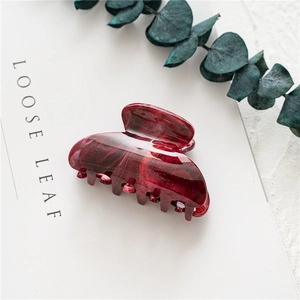 Close-up of a large wine red marble pattern acrylic hair claw clip with glossy finish