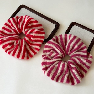 Detail of red and purple striped knit hair scrunchies with soft ribbed wool texture