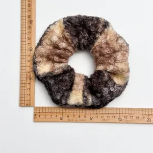 Flat lay of an oversized wool fleece scrunchie with measuring rulers showing 14cm size