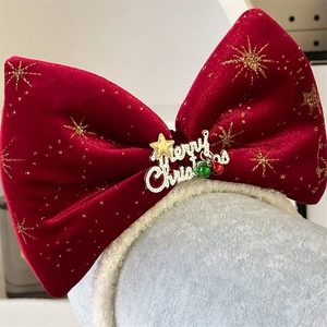 Close-up of red velvet Christmas headband with gold Merry Christmas lettering and stars