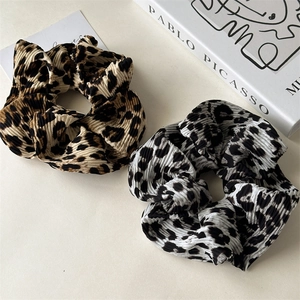 Close-up of leopard print hair scrunchies with pleated fabric texture and high elasticity