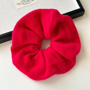 Detail of oversized fuchsia knit scrunchie showing soft texture and elastic pleats