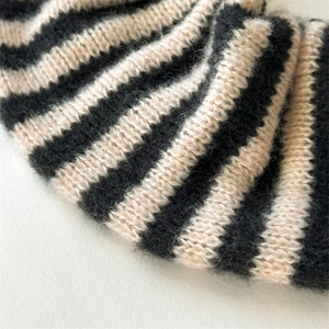 Macro shot of striped knit hair tie with fluffy mohair texture and ribbed pattern detail
