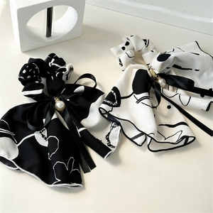 Detail of ink-style bow hair ties with elegant long ribbons and pearl pendants