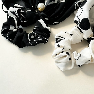 Close-up of ink wash style hair scrunchies with elegant imitation pearl pendants