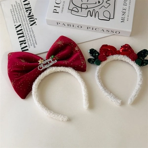 Flat lay of velvet red bow and sequin antler headbands with Christmas theme details