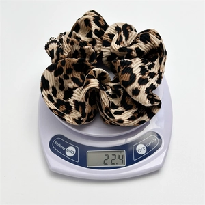 Leopard print pleated fabric scrunchie for women weighing 22.4g on a scale