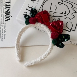 Detail of velvet Christmas headband with red sequins bow and reindeer antlers