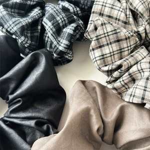 Gros plan de quatre chouchous variés à carreaux et unis dans les tons marron et noir