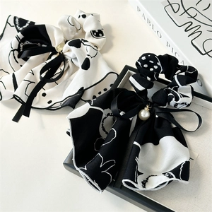 Detail of black and white ink-style chiffon scrunchies with pearls and ribbon bows
