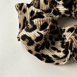 Macro detail of leopard print pleated fabric hair scrunchie with French vintage texture