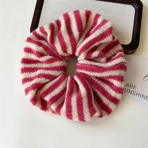Detailed view of pink and beige striped knit scrunchie with soft ribbed wool texture