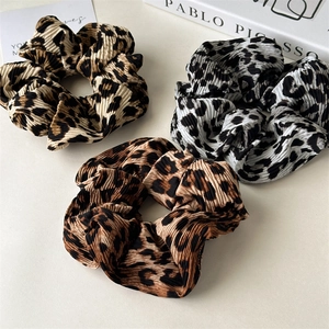 Three leopard print crinkle fabric scrunchies in brown and black hair accessory set