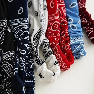 Detail of colorful paisley printed elastic headbands in black, navy, white and red colors