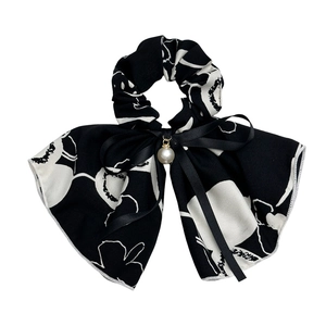Elegant black and white floral scrunchie with silk bow and pearl pendant on white background