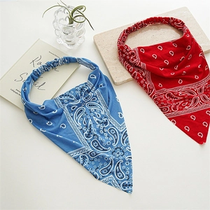 Flat lay of red and blue paisley triangle headbands with elastic bands on a white surface