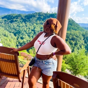Outdoor shot of a woman wearing a white graphic tank top with a paisley bandana headband