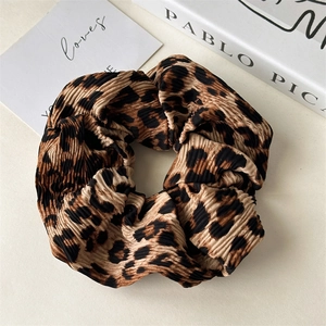 Close-up of leopard print pleated fabric scrunchie with high elasticity and soft texture