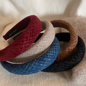 Macro view of textured tweed fabric headbands featuring premium hand-made label details