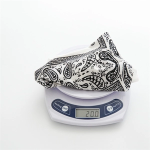 Detail view of a white paisley bandana on a scale weighing approximately 20 grams