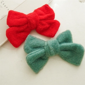 Détail de pinces à cheveux nœud en peluche rouge et vert foncé avec texture douce et soyeuse