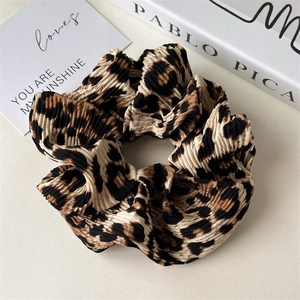 Detailed macro view of the leopard print pleated fabric and textured texture of the scrunchie