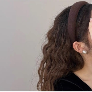 Detailed side view of thick ribbed knit headband in dark brown on a female model