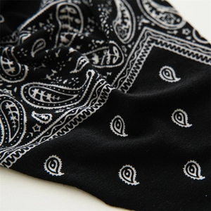 Macro detail of high-elastic black paisley bandana with precise textile weaving patterns