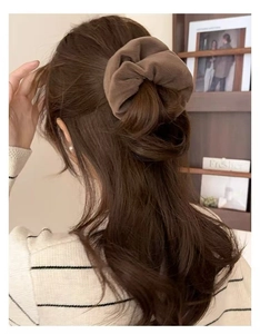 Detailed texture of dark brown plush velvet hair scrunchie with soft ruched fabric