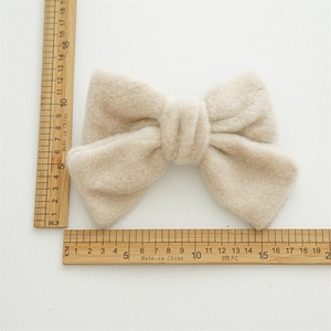Vue détaillée de la grande pince à cheveux nœud en peluche beige avec dimensions de 15cm