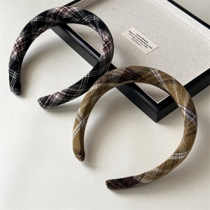 Vue détaillée des serre-têtes à carreaux de style preppy en tissu rouge et marron