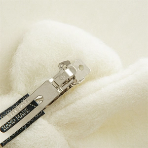 Détail de la barrette en métal faite main avec gravure et texture douce en fausse fourrure