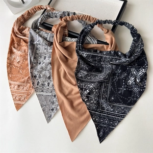 Detail of four bohemian paisley and solid elastic headbands set in neutral earth tones