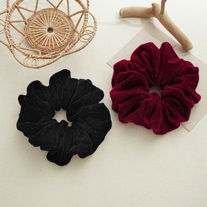Detail of high-elastic black and burgundy velvet scrunchies with elegant textures