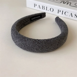 Detailed macro view of gray textured wool sponge headband with a handmade textile label