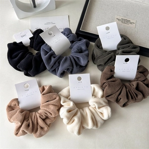 Detailed view of plush velvet scrunchies in six Morandi colors on white display cards