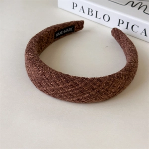 Detail of wide brown wool headband with textured fabric and handmade label