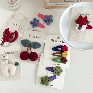 Macro detail of handmade crochet flower and cartoon alpaca hair clip set for kids