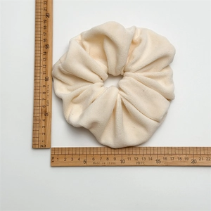Detailed size measurement of a 13.5cm oversized cream plush scrunchie showing soft texture